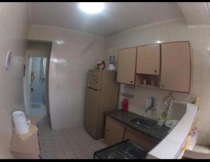 a small kitchen with a sink and a refrigerator at Casa Gomes in Praia Grande