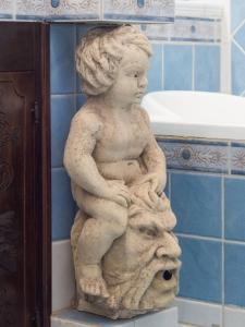 una estatua de un niño parado en un baño en Michelle House, en Torre Suda