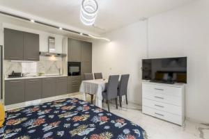 a kitchen and dining room with a table and a television at Royal Platinum Studio Apartment in Vodice