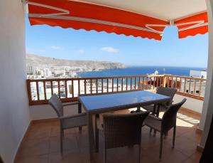 una mesa y sillas en un balcón con vistas al océano en Apartment Cactus II Los Cristianos, en Los Cristianos