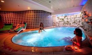 un grupo de mujeres sentadas alrededor de un jacuzzi en Grand Denizli Hotel, en Denizli