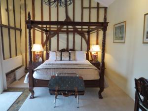 a bedroom with a large bed with a wooden frame at The Greyhound - Historic former Inn in Glemsford