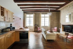 a kitchen and living room with a couch and a table at charme d'ancien au coeur de vieux-tours in Tours