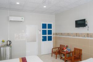 a room with two chairs and a table and a television at HIEP HOA HOTEL in Chau Doc