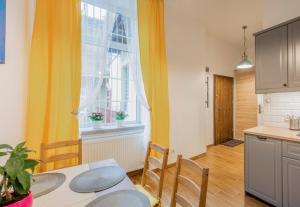 cocina y comedor con mesa y ventana en Apartamenty Kamienica Rzeszów, en Rzeszów