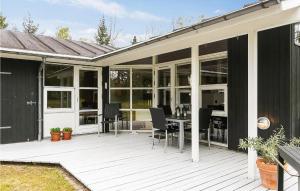 a screened in porch with a table and chairs at Awesome Home In Gedser With Sauna in Gedser