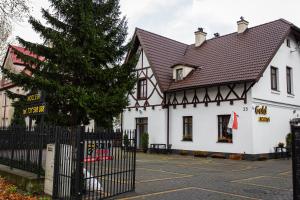 un edificio blanco con techo negro en Pensjonat Gold Rooms, en Koszalin