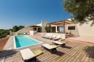 einen Pool mit Liegestühlen und ein Haus in der Unterkunft Villa Sofia by BarbarHouse in Carovigno