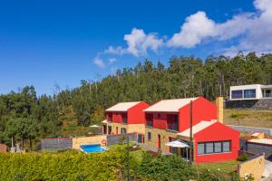 dom z czerwonymi dachami na wzgórzu w obiekcie Vilas Felicidade Rocha by An Island Apart w mieście Ponta do Pargo