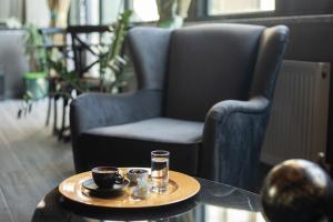 a table with two cups of coffee and a chair at Hotel Cura in Çanakkale