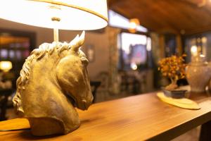 a bronze horse head on a table with a lamp at Hotel Cura in Çanakkale