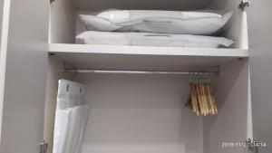 a white closet with white towels on shelves at B&B La Stazione in Diamante +184 photos