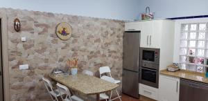 a kitchen with a table and a stone wall at A Fragua in Tapia de Casariego