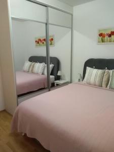 a bedroom with a large white bed and a mirror at Apartment Kraljica in Banja Koviljača