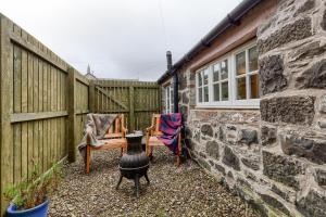 a backyard with a brick wall and a fire pit at Dundas Flat, 1 bedroom, Comrie in Comrie