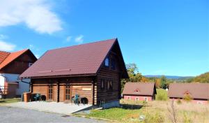 eine große Holzhütte mit rotem Dach in der Unterkunft Chata Roubenka - Jesenka in Dolní Moravice