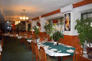 a dining room with tables and chairs in a restaurant at Slavyanska Beseda Hotel in Sofia