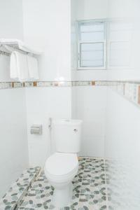 a white bathroom with a toilet with a hose at HIEP HOA HOTEL in Chau Doc