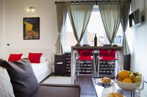 a living room with a couch and a table with a bowl of fruit at Studio apartment with a view of Ban Jelačić Square in Zagreb