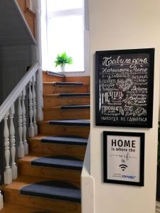 A stairway with a chalkboard sign and a home is where i am w obiekcie Pelican Guest House & Hostel w Czerniowcach