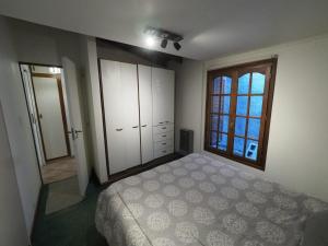 1 dormitorio con cama y ventana grande en Santa Lucia en Ushuaia