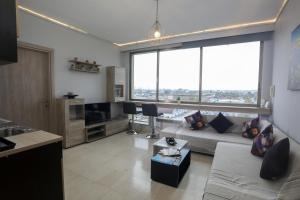 a living room with a couch and a large window at IRIS Apartment in Thessaloniki