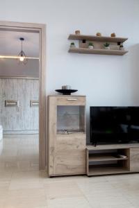 een woonkamer met een tv en een houten entertainmentcentrum bij IRIS Apartment in Thessaloniki