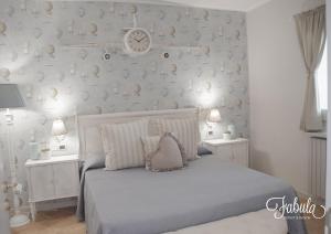 a bedroom with a bed with a clock on the wall at Masseria Fabula Bistrot & Maison in Monopoli