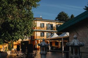 a building in the background with two lights in front at Hotel La Valle dell'Aquila in LʼAquila
