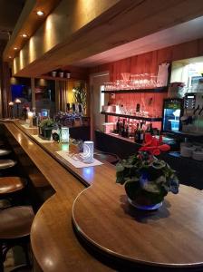 un bar avec un vase de fleurs sur une table dans l'établissement Hotel-Cafe Knoors-Meeks Stein Urmond, à Berg