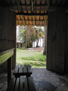 昆幕露夏其巴的住宿－Hospedaria Cumuruxatiba，坐在大楼入口处的木凳