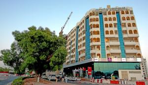 a tall building with a crane on top of it at Manhattan Avenue Hotel in Dubai