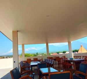 a restaurant with tables and chairs with a view at Bluefire Homestay Syariah in Banyuwangi