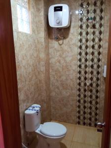 a small bathroom with a toilet and a window at Bluefire Homestay Syariah in Banyuwangi