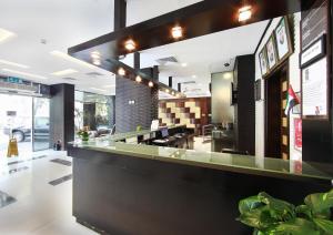 a restaurant with a long counter with at Manhattan Avenue Hotel in Dubai