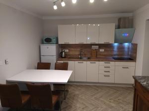 a kitchen with white cabinets and a table and chairs at Apartmaji Maln in Dolenjske Toplice