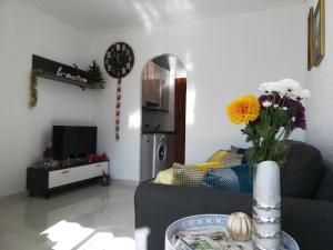 een woonkamer met een bank en een vaas met bloemen bij Lovely home La Mata pool&beach in Torrevieja