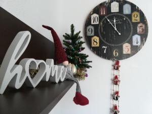 Eine Uhr mit einem Santa-Hut neben einem Weihnachtsbaum in der Unterkunft Lovely home La Mata pool&beach in Torrevieja