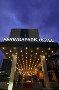 a building with a sign on top of it with lights at Feringapark Hotel Unterföhring in Munich