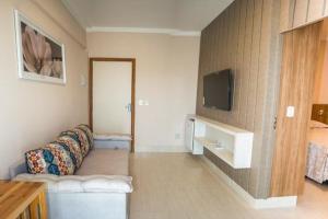 a living room with a couch and a flat screen tv at Piazza DiRoma Caldas Novas in Caldas Novas