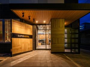 een toegang tot een winkel met houten deuren bij Super Hotel Matsumoto Tennenonsen in Matsumoto
