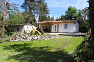 a small white house with a fence and a yard at ZumSeehörnchen Haus Schmetterling in Tanna