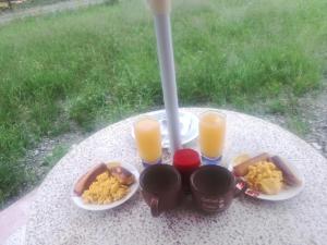 uma mesa com dois pratos de comida e dois copos de sumo de laranja em QUINTA PRIMAVERA - Hostería Campestre em Nueva Loja