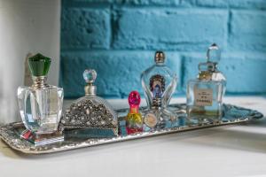 a tray with three perfume bottles on a shelf at Somerset Stables in Graaff-Reinet