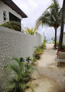 une passerelle à côté d'un bâtiment avec des palmiers et l'océan dans l'établissement Easy Stay Residence, à Trou aux Biches