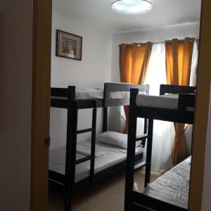 una camera con 3 letti a castello e una finestra di 614 Anabelle Residence at Marina Spatial Condominium a Dumaguete