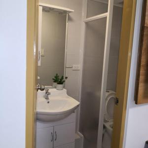 La salle de bains est pourvue d'un lavabo, d'un miroir et de toilettes. dans l'établissement 614 Anabelle Residence at Marina Spatial Condominium, à Dumaguete