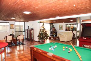 sala de estar con mesa de billar y árbol de Navidad en Hotel Salvador, en Poços de Caldas