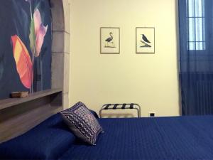 ミラノにあるスイート アメデイ 4のベッドルーム1室(青いベッド1台、壁に鳥1羽付)