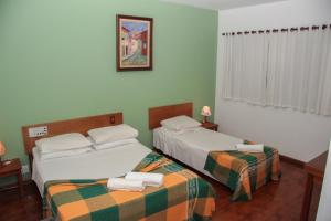 Una habitación de hotel con dos camas con toallas. en Hotel Salvador, en Poços de Caldas 53 fotos más